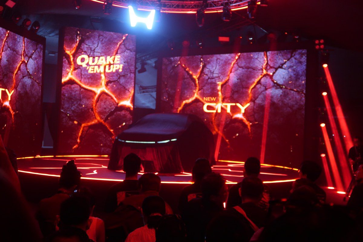 ภาพงานเปิดตัวรถยนต์ใหม่ที่มีการจัดแสดงบนเวทีพร้อมแสงสีสันสดใส.