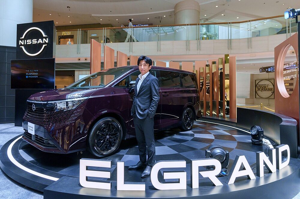 ผู้บริหารยืนคู่กับ Nissan Elgrand e-POWER 2026 บนแท่นจัดแสดงในฮ่องกง
