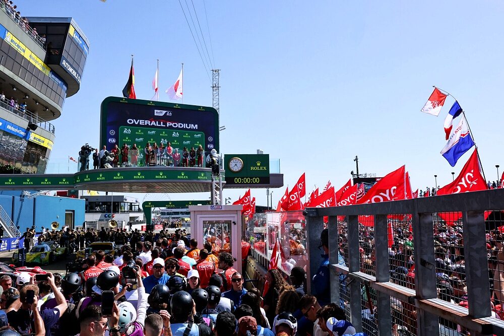 Motorsport fans in front of the 2026 Le Mans 24 Hours podium screen