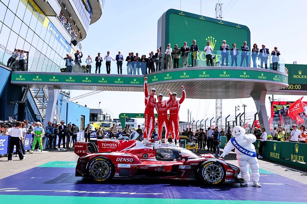 Toyota TR010 HYBRID number 7 parked below the overall podium