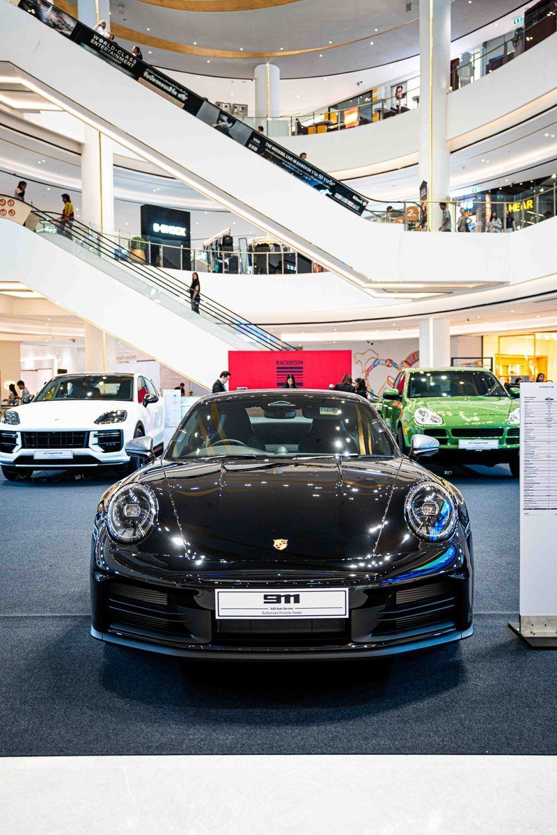 ภาพรถยนต์ Porsche 911 สีดำที่จัดแสดงในงานเปิดตัวรถยนต์ภายในห้างสรรพสินค้า.