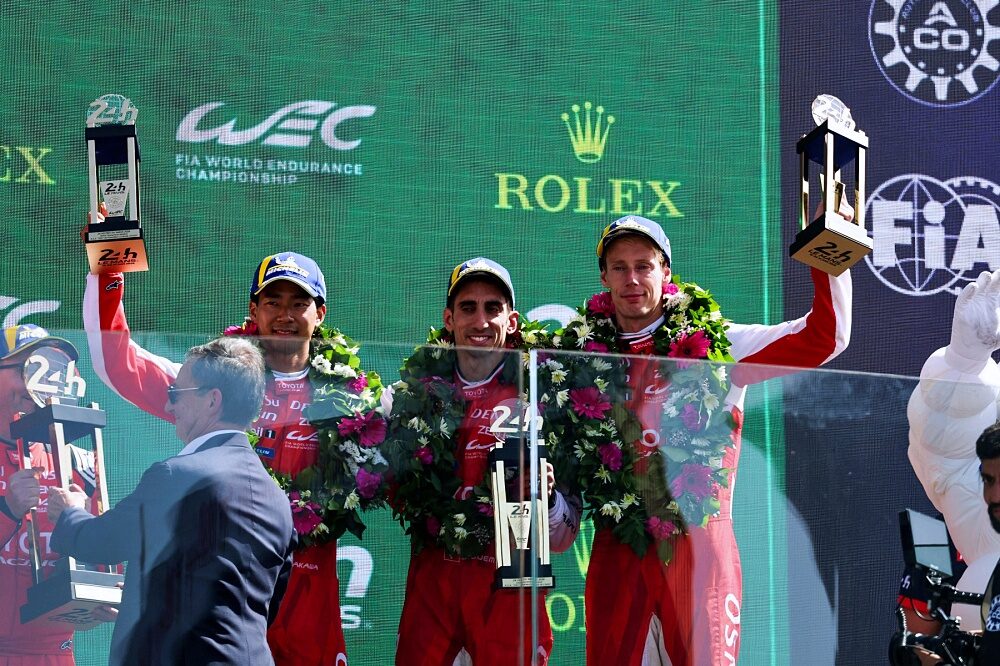 Mike Conway Kamui Kobayashi and Nyck de Vries on the 2026 Le Mans podium
