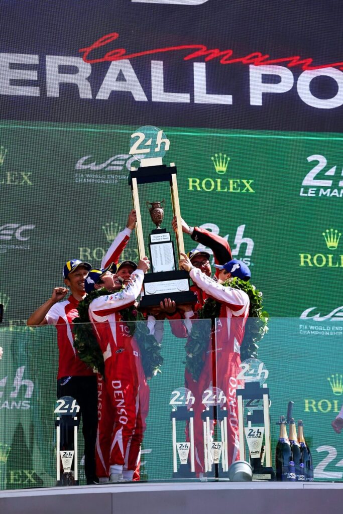 Toyota Racing driver lifts the trophy on the overall podium
