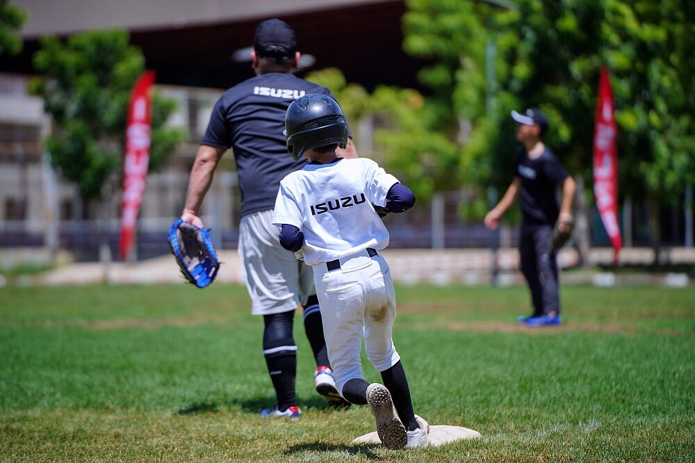 Thailand U12 youth baseball players in a practice game with umpire