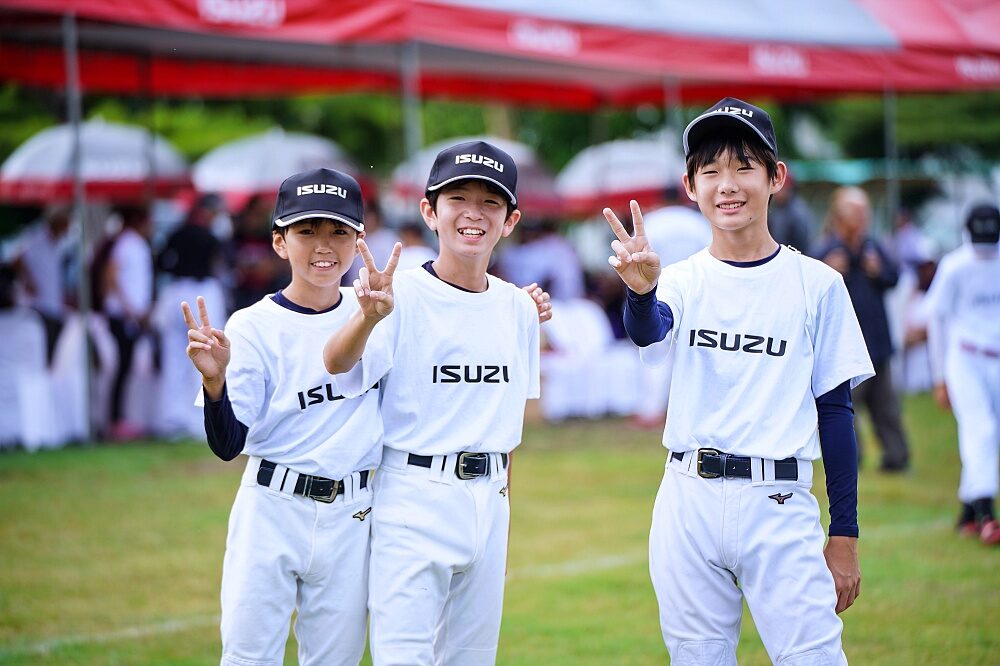 Thailand U12 youth baseball players stand with training equipment