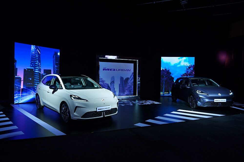 ภาพมุมกว้างของรถยนต์ไฟฟ้า MG URBAN 2026 ทั้งสีขาวและสีเทาเข้มจอดแสดงบนเวทีร่วมกัน