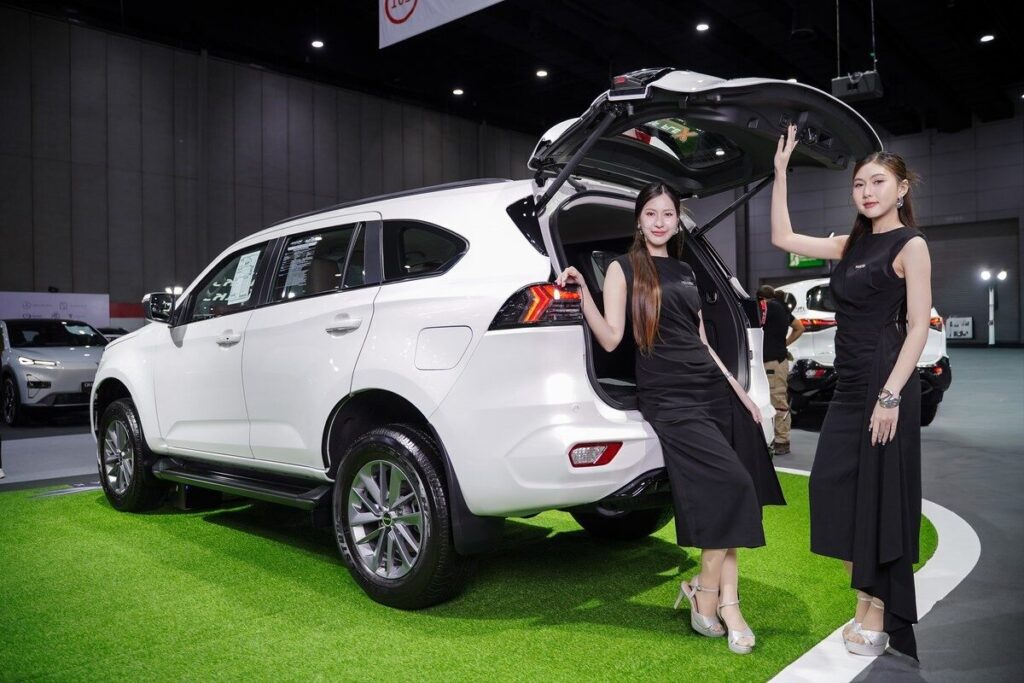 พรีเซนเตอร์ Isuzu กับ MU-X สีขาวเปิดฝาท้ายในงาน FAST Auto Show 2026