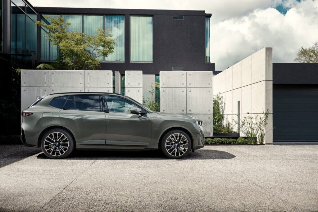 BMW iX5 60 xDrive 2026 มุมด้านข้างหน้าอาคาร