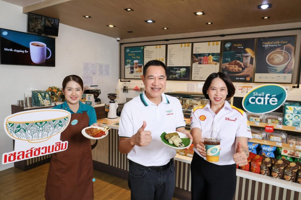 ผู้บริหารเชลล์ ม.ล.ภาสันต์ และพนักงานร้าน ถือเมนูเชลล์ชวนชิมในร้าน Shell Café
