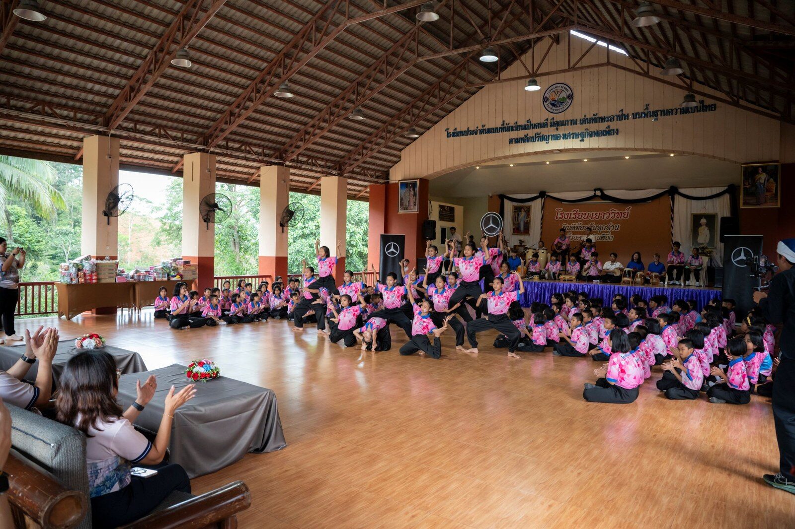 นักเรียนโรงเรียนเยาววิทย์แสดงการละเล่นบนเวทีหอประชุม ท่ามกลางผู้ชมและคณะผู้บริหาร