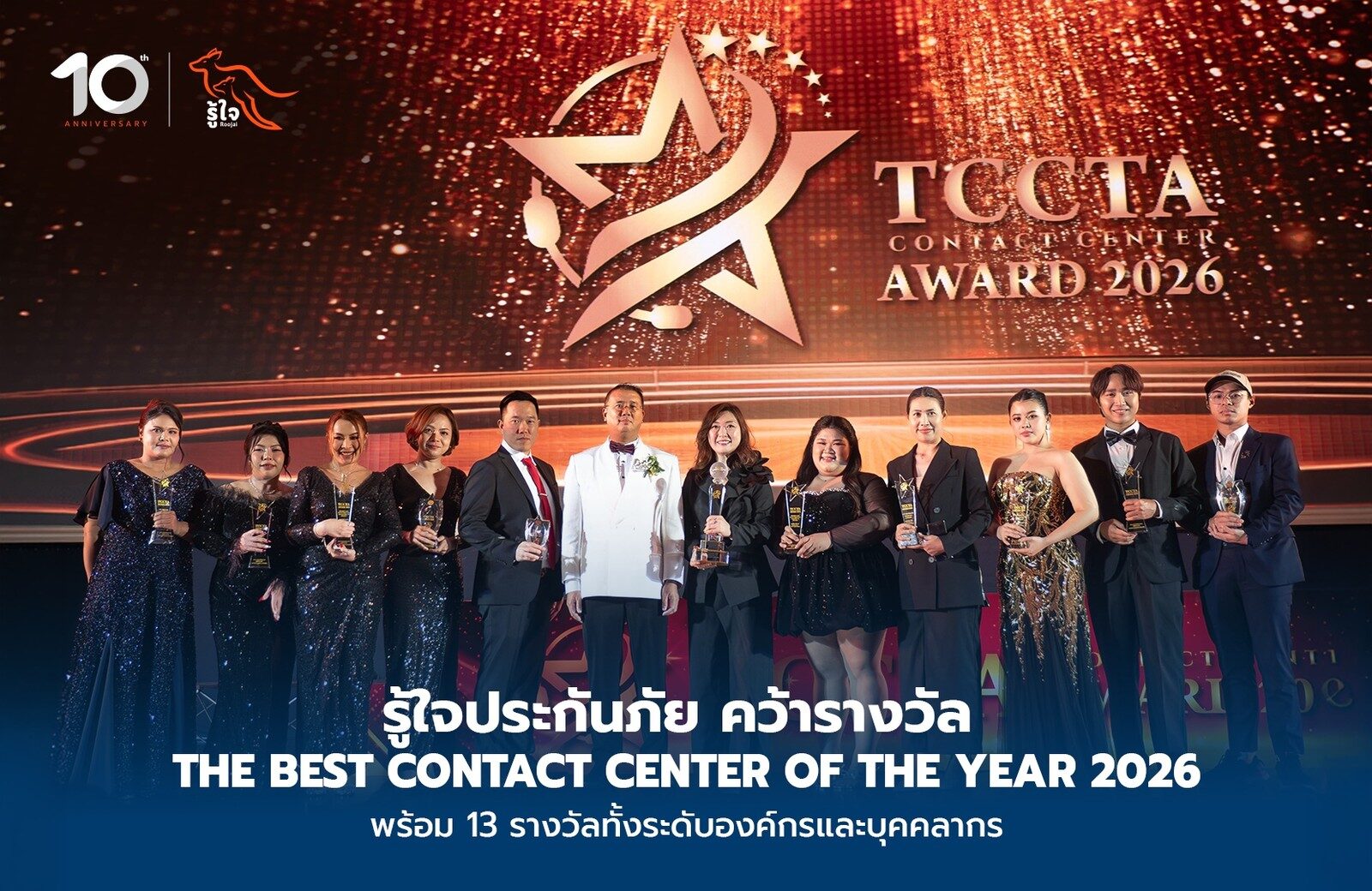 ทีมงานรู้ใจถือถ้วยรางวัลยืนเรียงหน้าฉาก TCCTA Award 2026