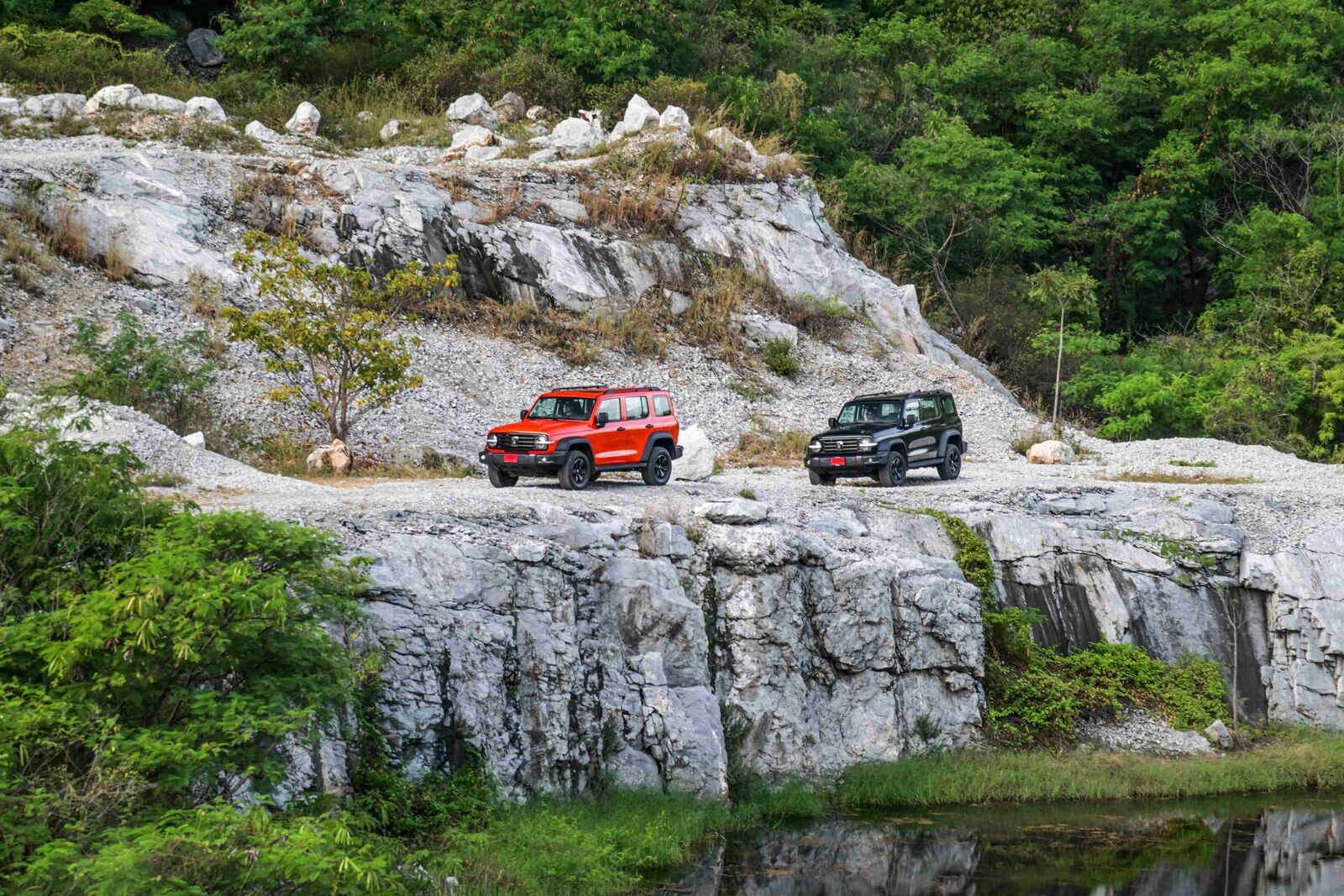 รถ GWM TANK สีส้มและสีดำจอดบนเส้นทางหินปูนกลางธรรมชาติ