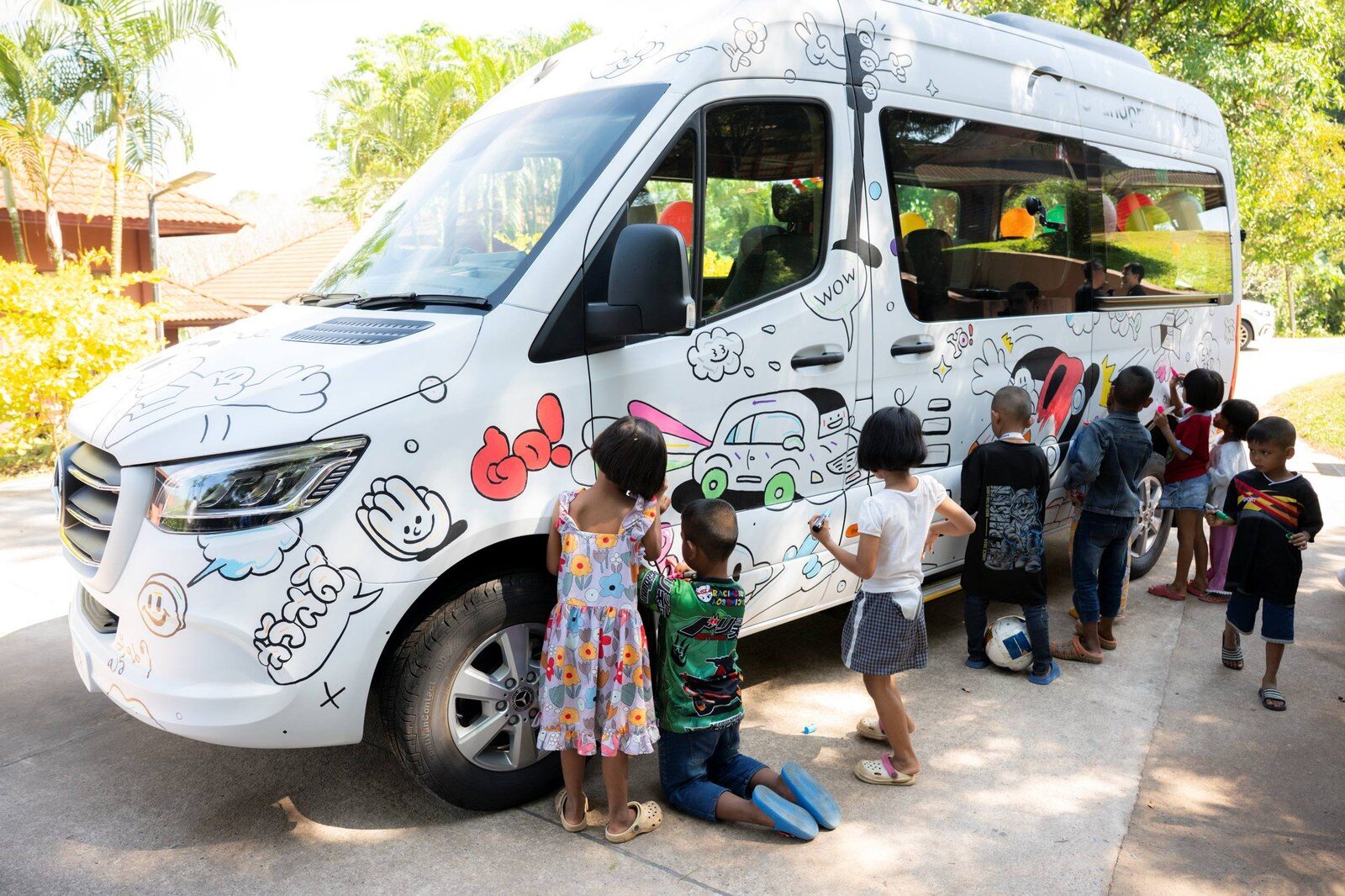เด็ก ๆ ระบายสีลงบนรถ Mercedes-Benz Sprinter สีขาวที่โรงเรียนเยาววิทย์