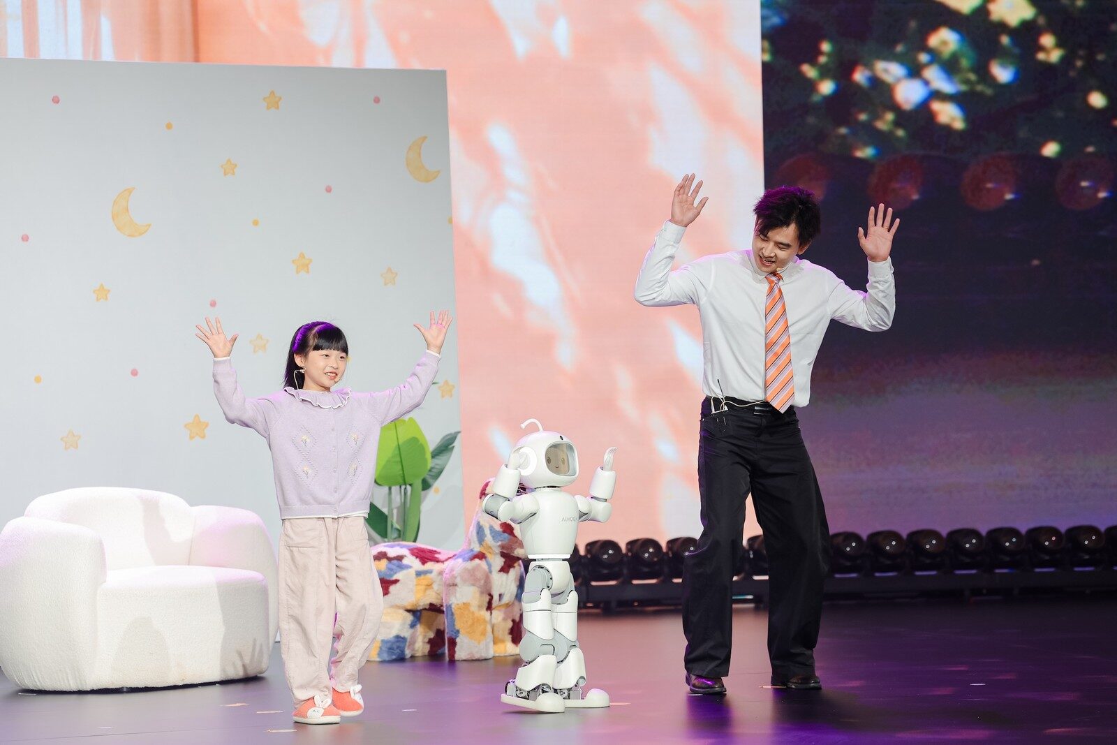 Mobo ยกแขนแสดงท่าทางร่วมกับเด็กและผู้ใหญ่บนเวทีเปิดตัว
