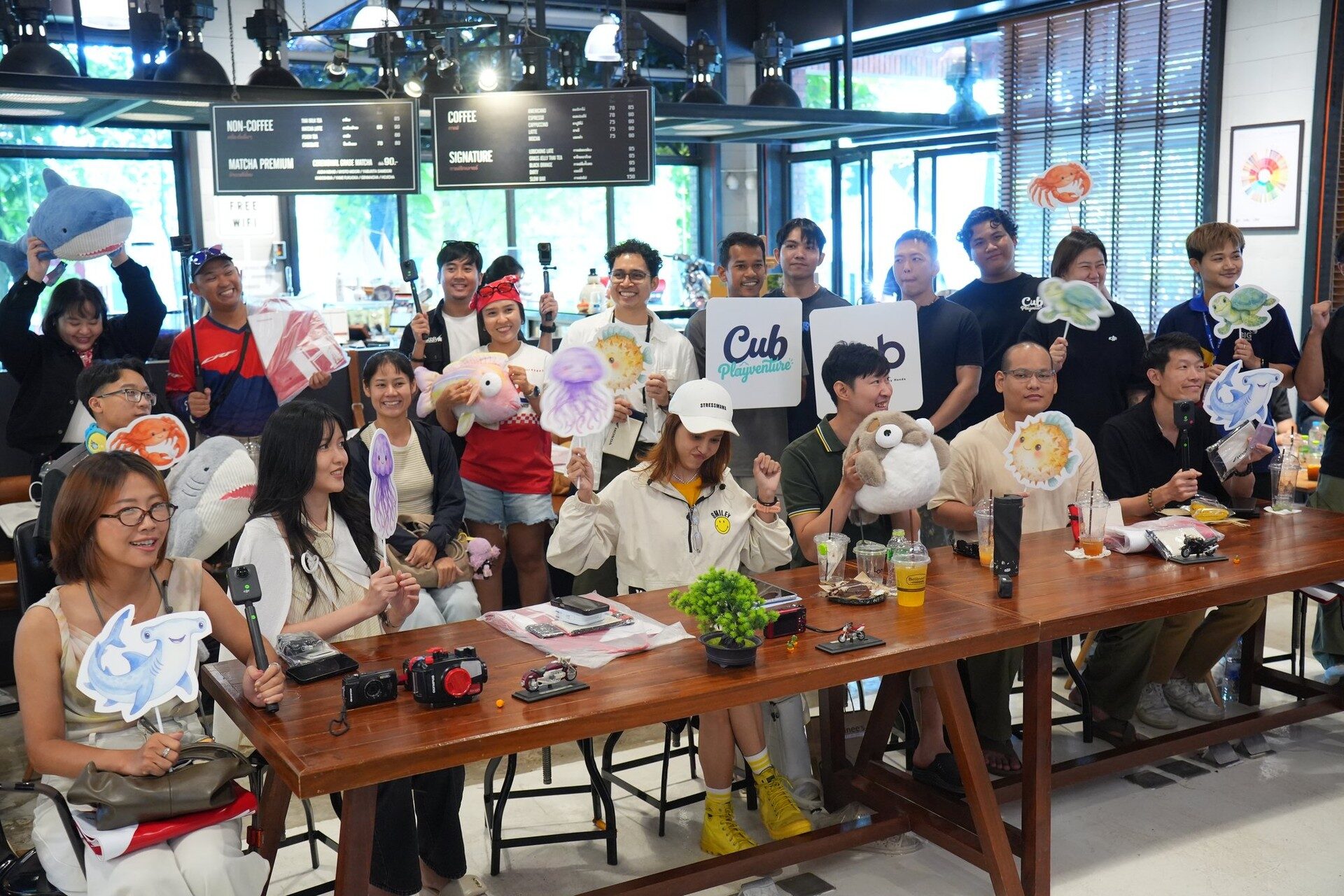 ผู้ร่วมทริป CUB PLAYVENTURE ถือป้ายและพร็อพสัตว์ทะเลในร้าน CUB House ระยอง