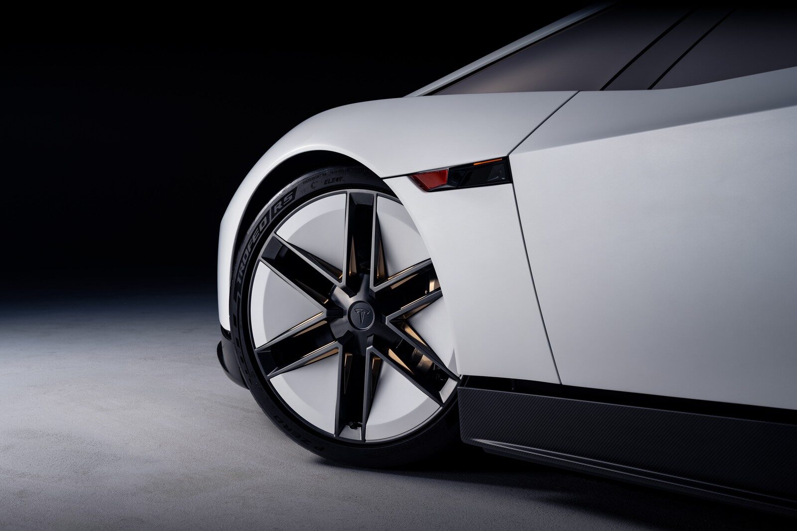 ล้อหน้าซี่เรียวและซุ้มล้อของ Roadster สีขาวใกล้ชิด