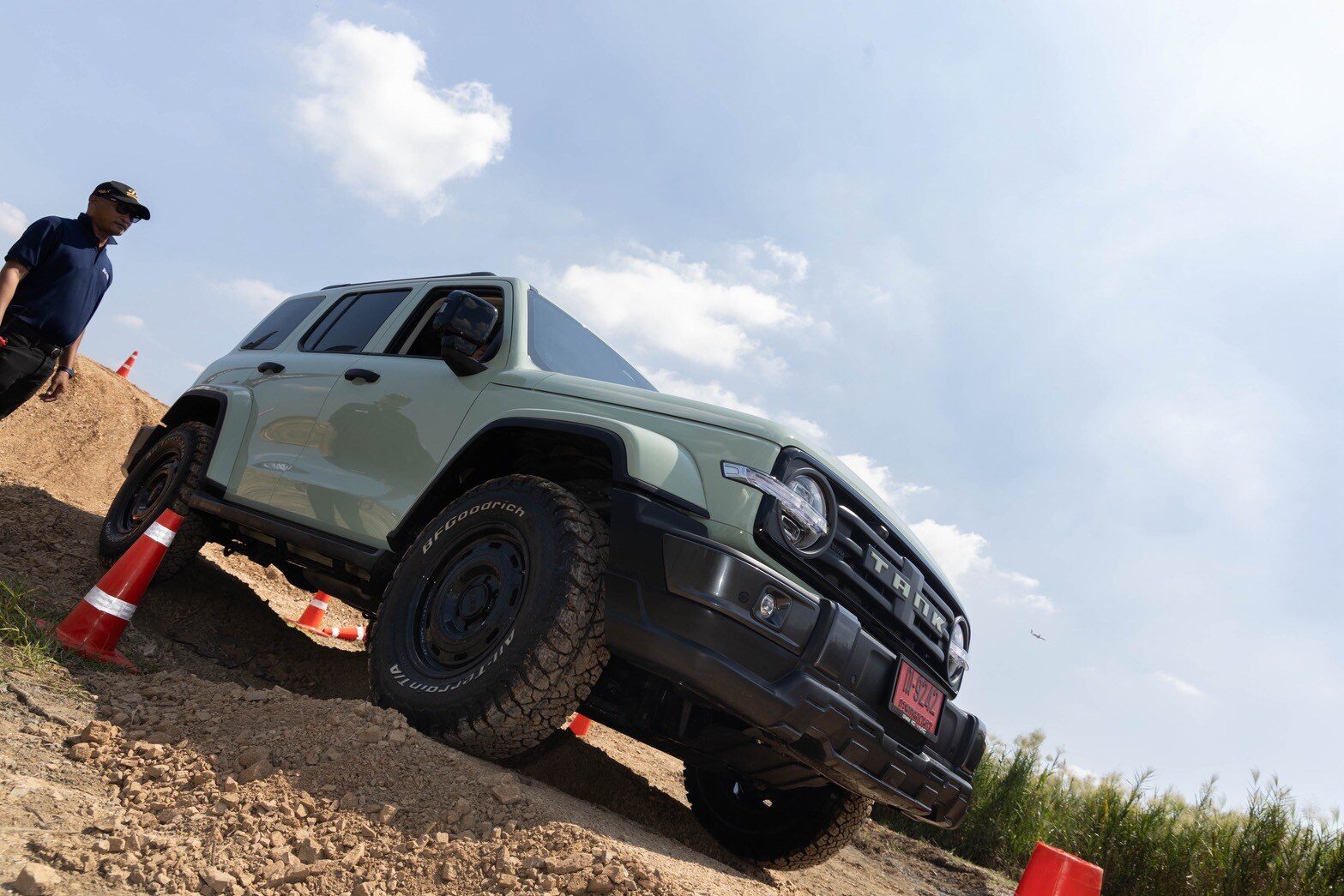 GWM Tank สีเขียวขับผ่านหลุมและเนินในสนามจำลอง