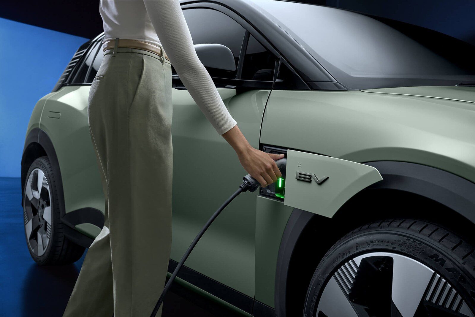 ผู้หญิงเสียบสายชาร์จเข้าช่องชาร์จของ Mitsubishi ASX VR-e