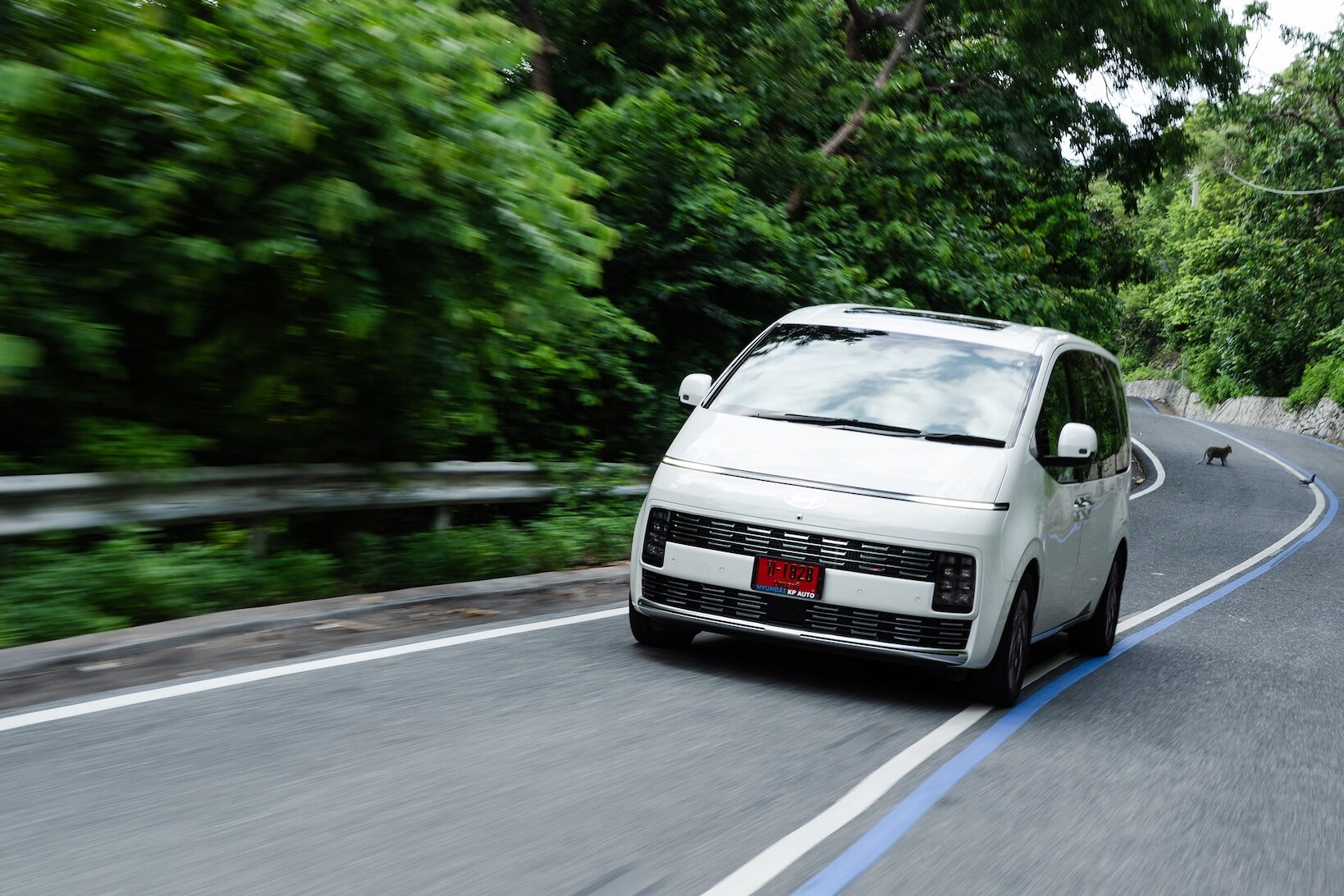 Hyundai STARIA Hybrid 2026 สีขาว วิ่งบนถนนเลียบเขา