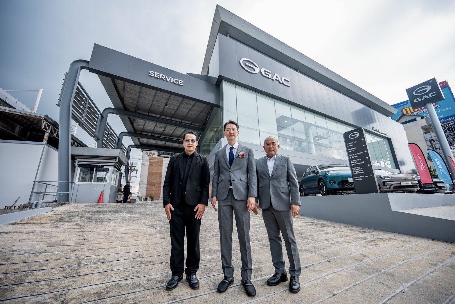 ผู้บริหาร 5 ท่านยืนถ่ายภาพหน้าฉากพิธีเปิด GAC M18 Mobility