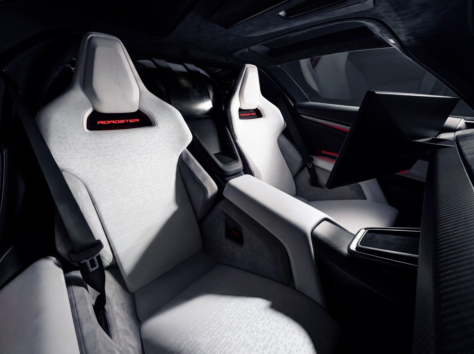 เบาะสีขาวสองที่นั่งพร้อมป้าย Roadster บนพนักพิงศีรษะ