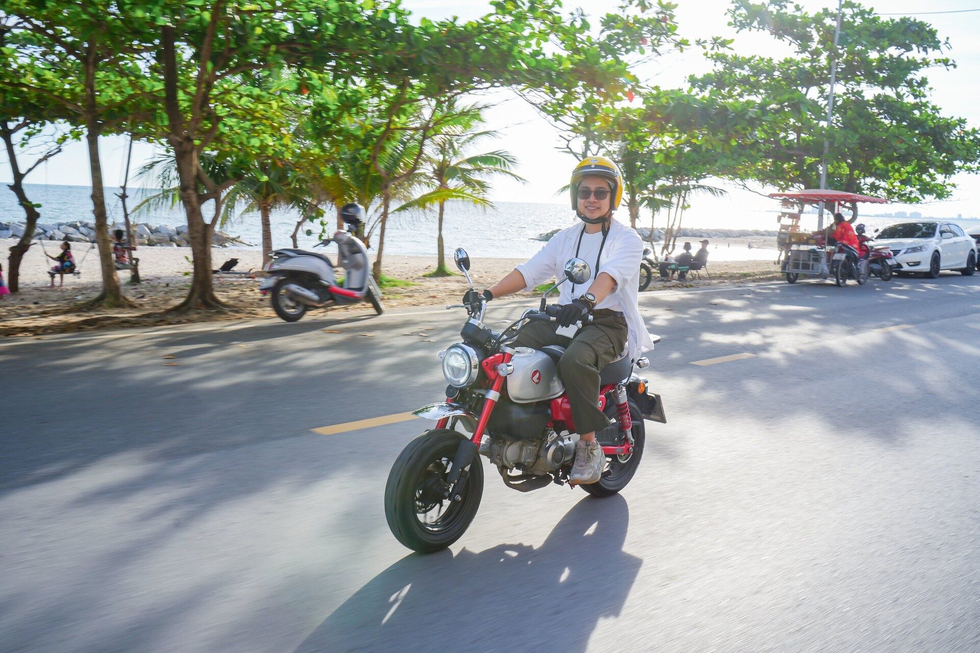 ผู้ร่วมทริปขี่ Honda Monkey สีแดงเลียบชายหาด