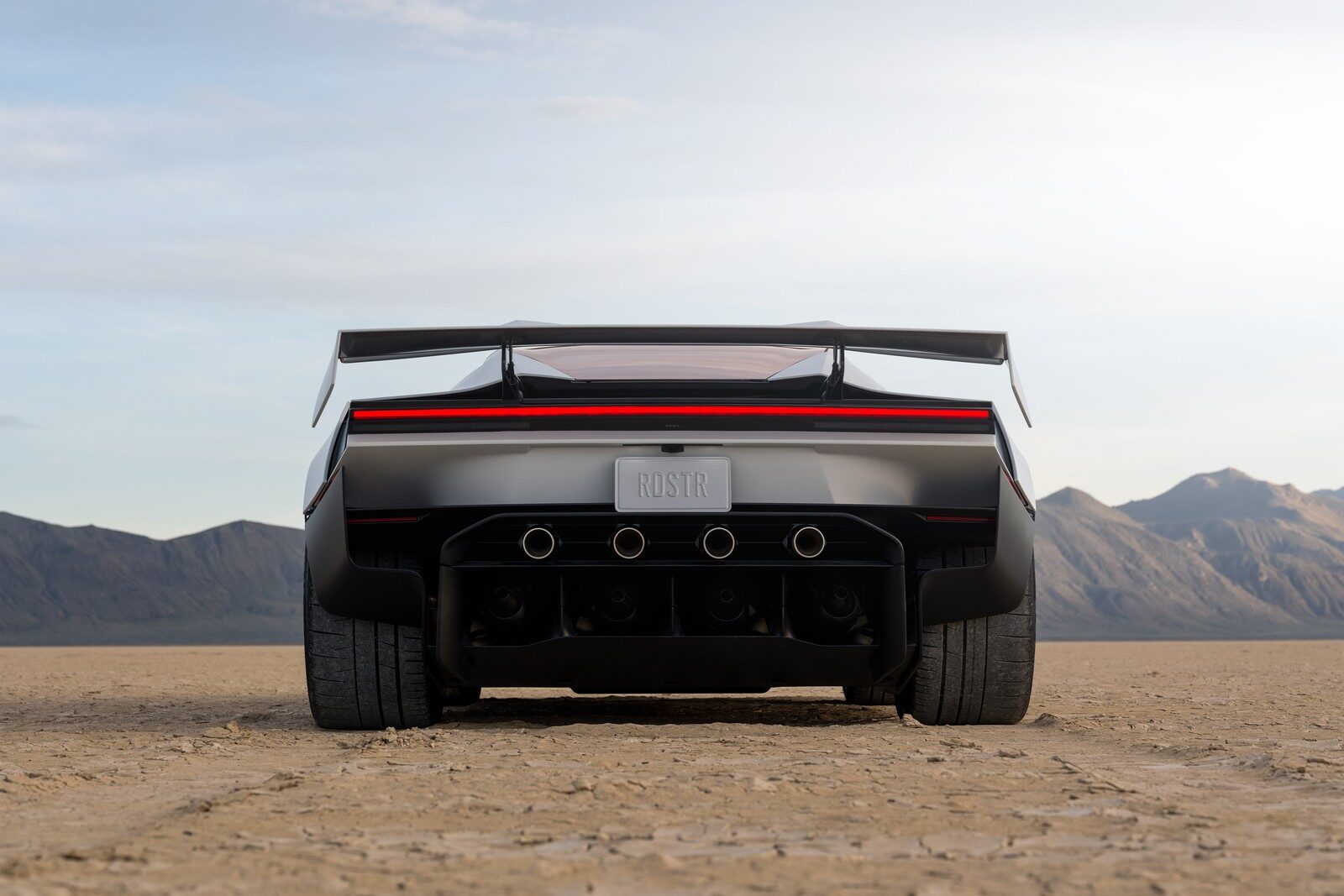 ด้านท้าย Roadster พร้อมปีกท้ายและไฟท้ายบนพื้นทะเลทราย