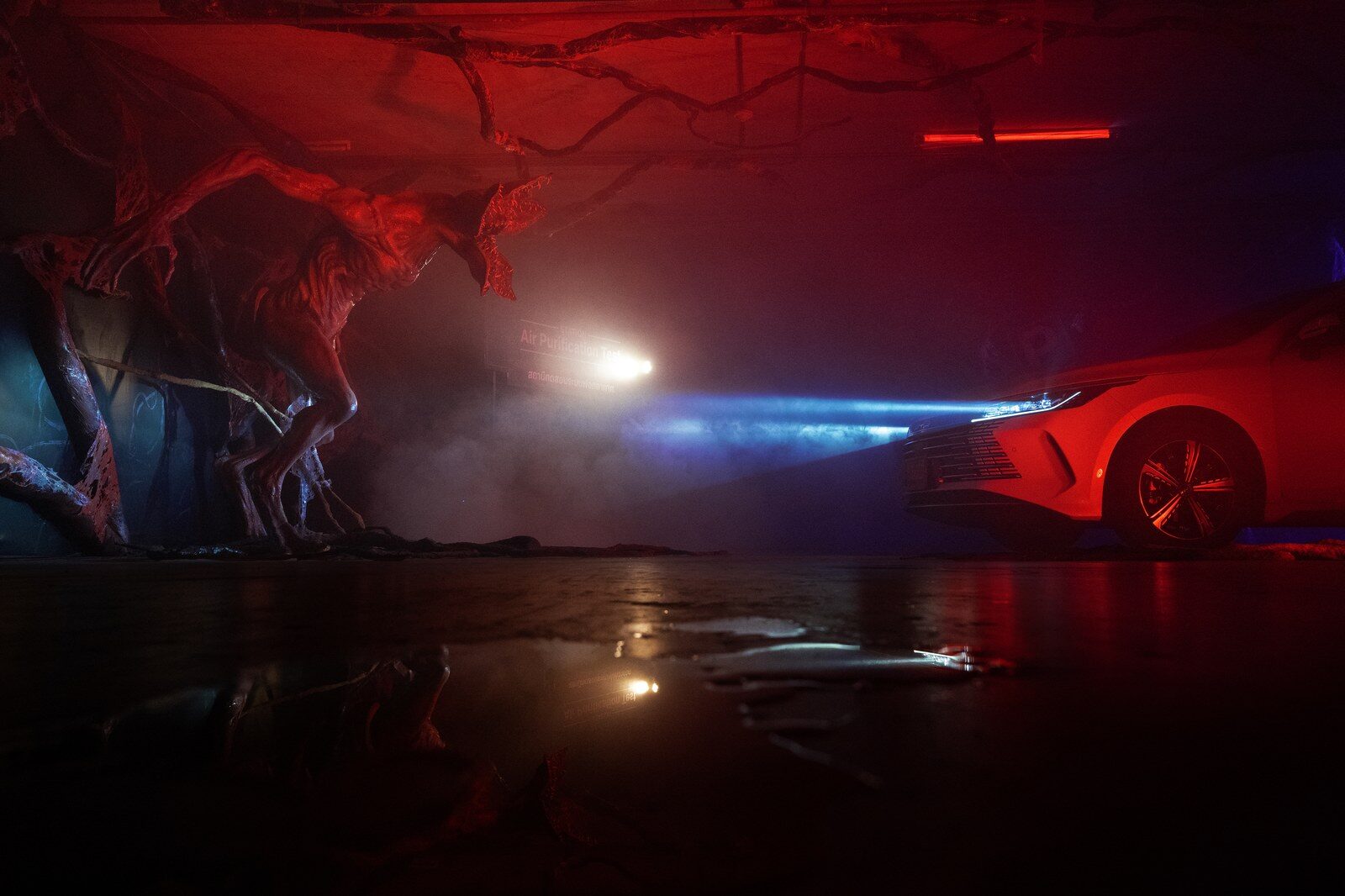 BYD ซีดานสีขาวใต้แสงสีแดงอยู่ข้างหุ่นสิ่งมีชีวิตในฉากธีม Stranger Things