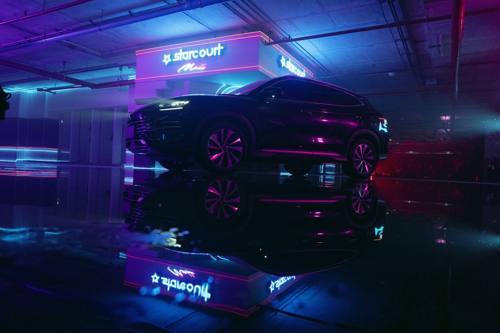 BYD SUV สีดำจอดหน้าฉากป้ายนีออน starcourt บนพื้นเงาสะท้อนแสงสีม่วงน้ำเงิน