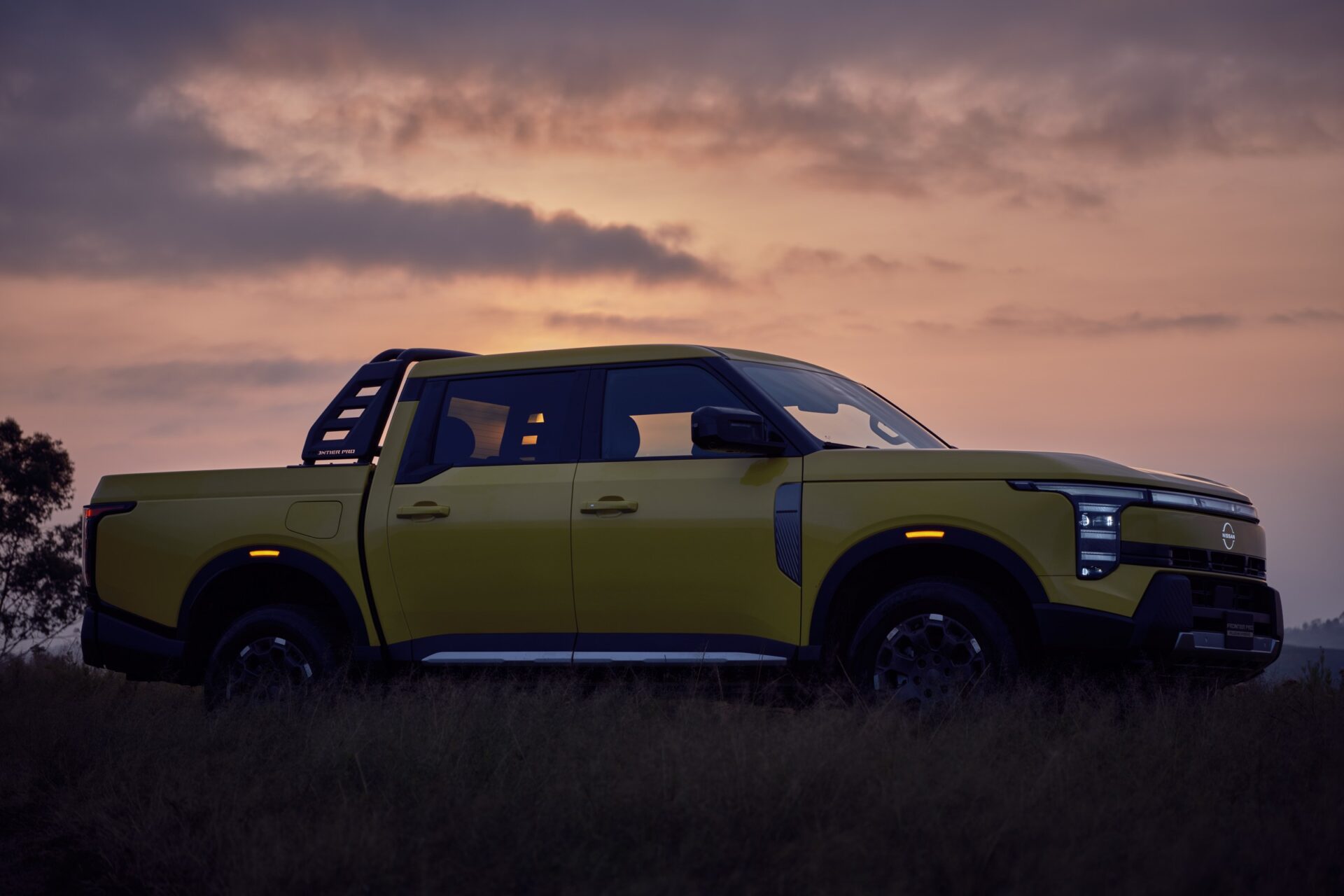 Nissan Frontier Pro ด้านข้างบนทุ่งหญ้าตอนพระอาทิตย์ตก
