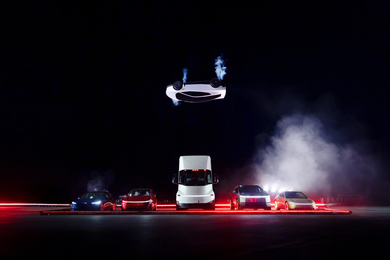 Roadster ในท่ากลับหัวเหนือรถ Tesla หลายรุ่นที่จอดเรียงอยู่