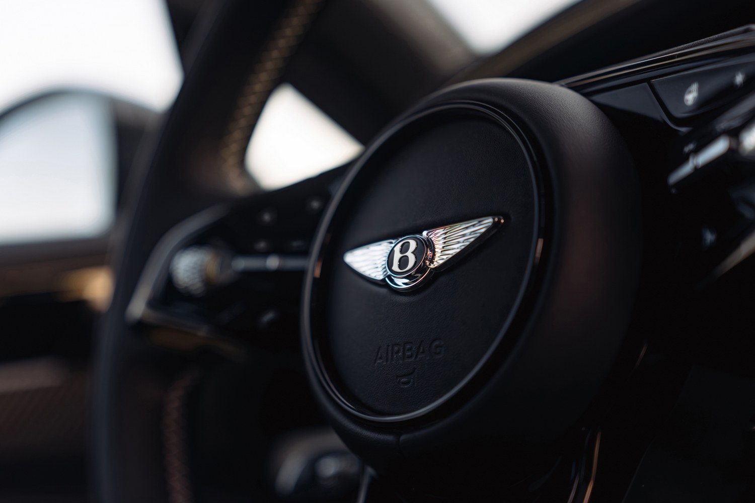 ภาพระยะใกล้พวงมาลัยพร้อมโลโก้ Bentley Wings