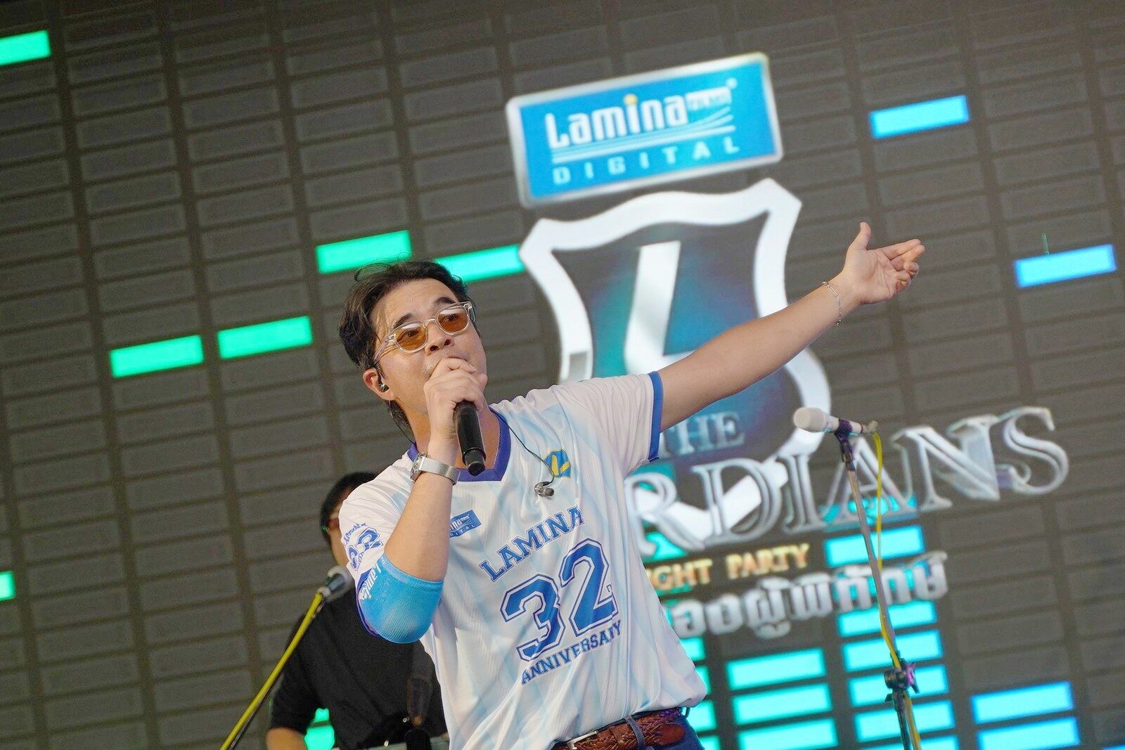 ศิลปินในเสื้อ Lamina 32 Anniversary ร้องเพลงบนเวที
