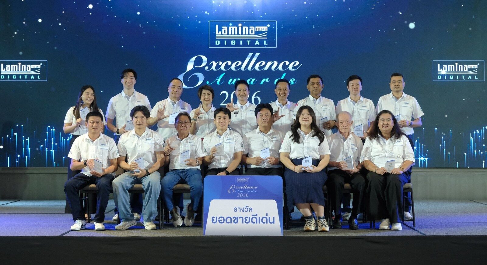 ผู้ได้รับรางวัลยอดขายดีเด่นถ่ายภาพหมู่หน้าป้ายรางวัล