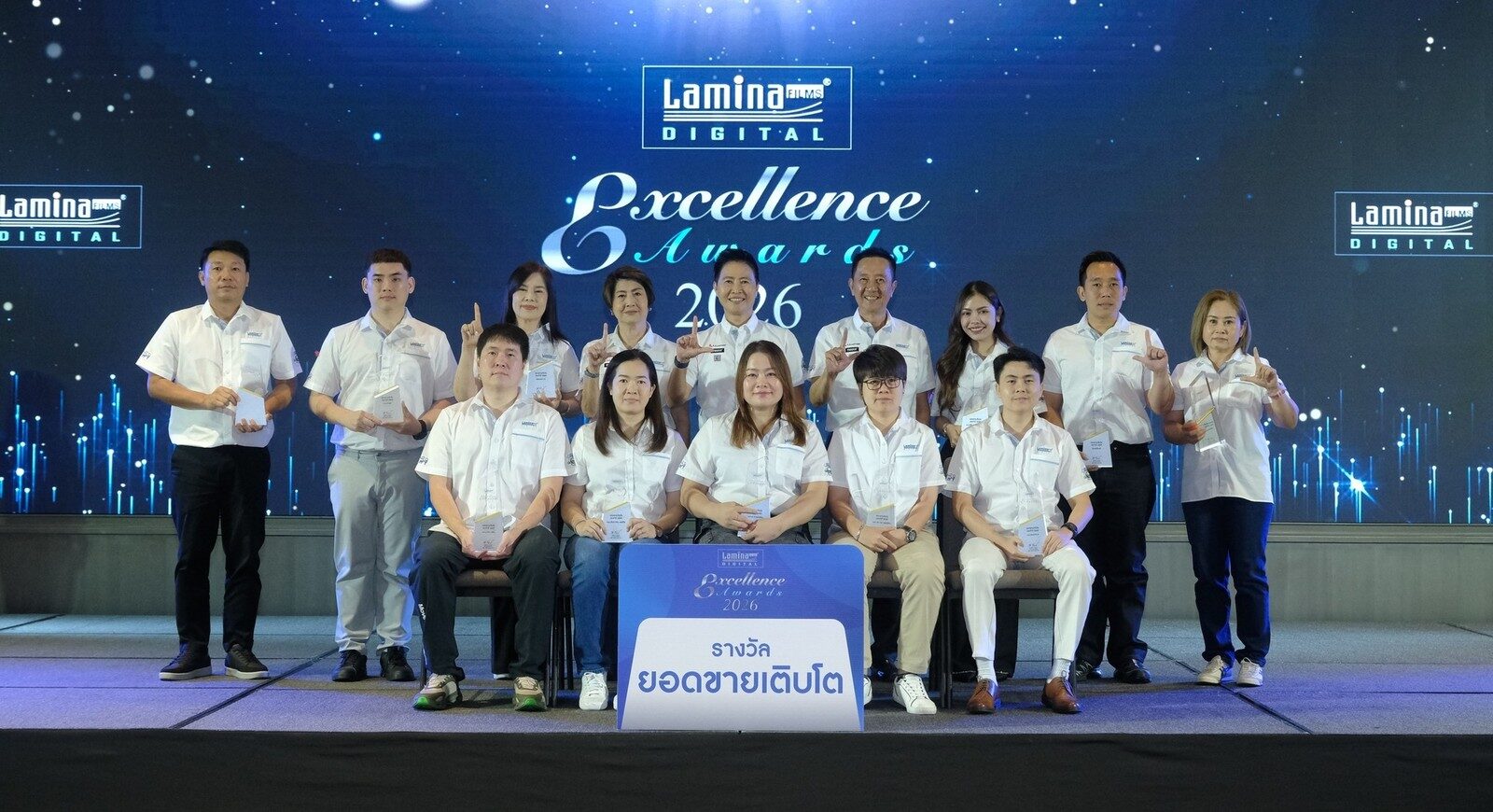 ผู้ได้รับรางวัลยอดขายเติบโตถ่ายภาพหมู่หน้าป้ายรางวัล