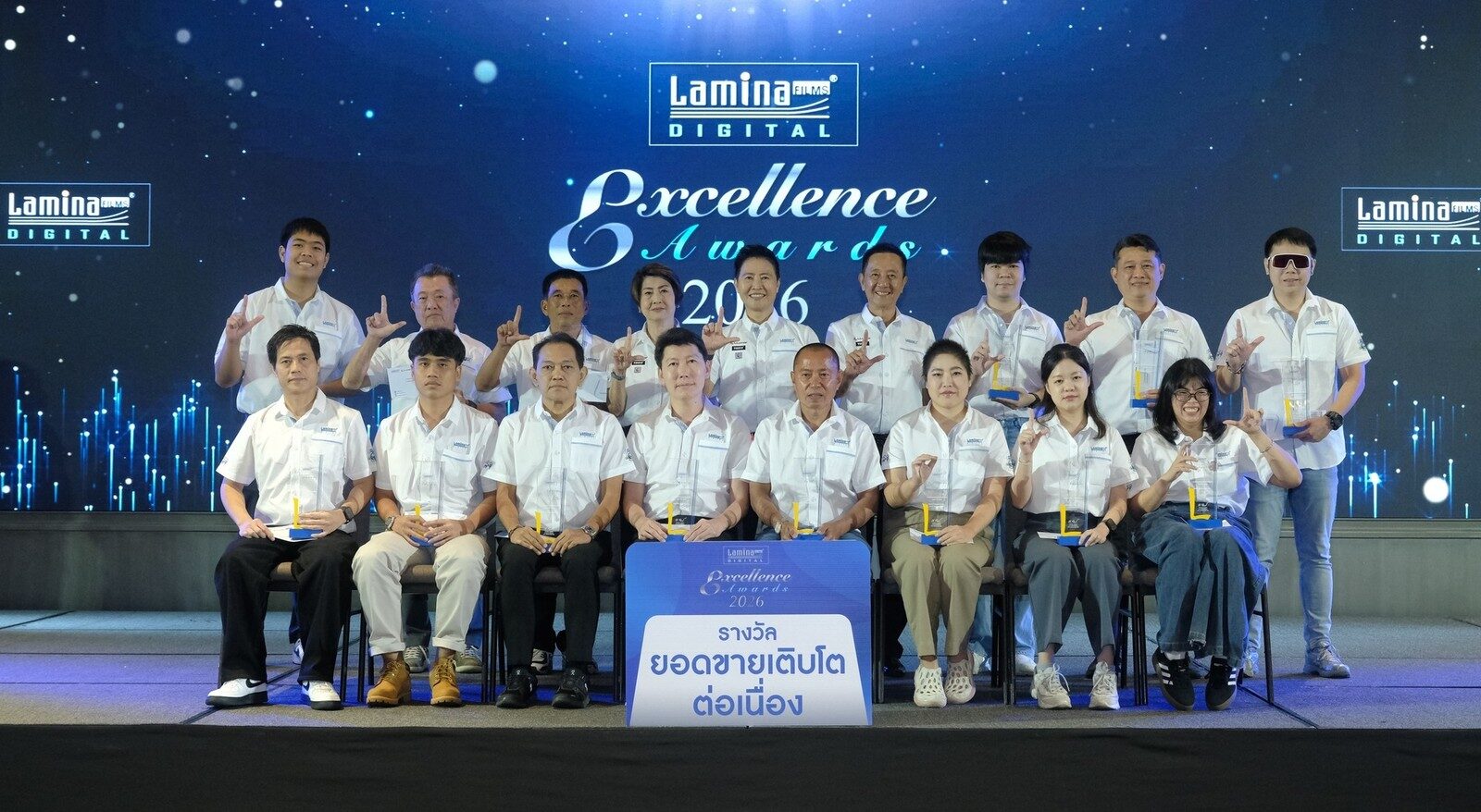 ผู้ได้รับรางวัลยอดขายเติบโตต่อเนื่องถ่ายภาพหมู่หน้าป้ายรางวัล